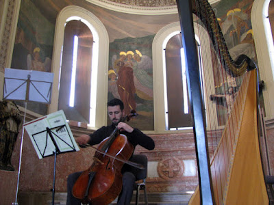 Homem tocando violoncello numa capela