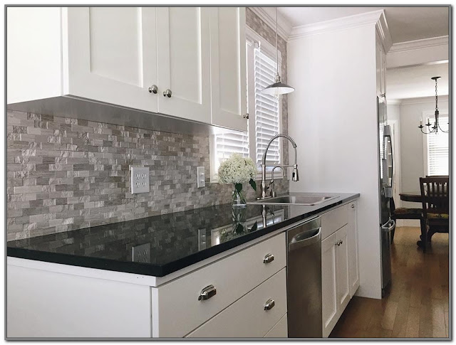 black kitchen cabinets with white marble countertops