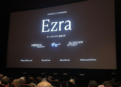 Promo screen for the movie Ezra, with white text on a black screen, as seen above the seated crowd in the SVA movie theater.