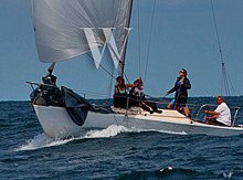 J/24 one-design sailboat- sailing fast down surfing wave