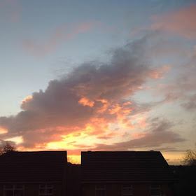 picture of sunrise with houses silhouetted 