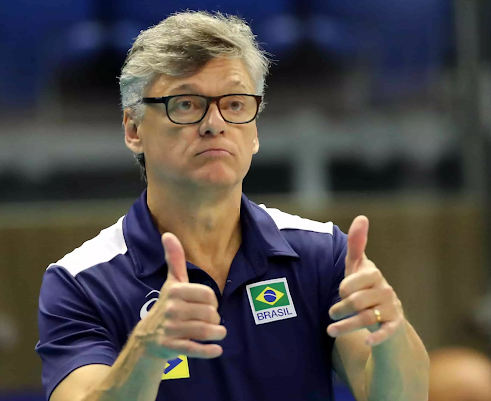Renan de frente para a câmera faz sinal de positivo com os polegares levantados, usa camisa azul do Time Brasil.