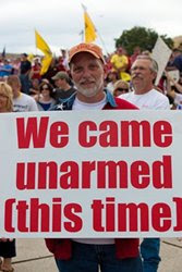 Nut with sign reading 'WE CAME UNARMED (THIS TIME)'