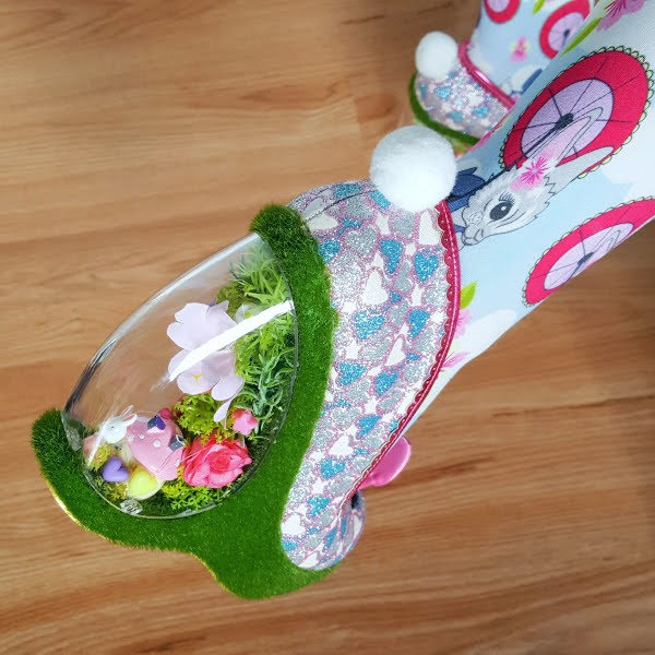 close up of garden heel casing on shoe with bunny figure and flowers inside