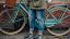 Person in Brown Jacket Standing Beside Bicycle