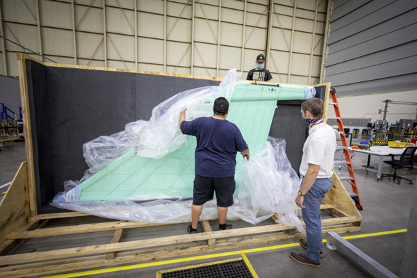 At Lockheed Martin's Skunk Works facility in Palmdale, California, workers uncrate the vertical stabilizer that will fly on NASA's X-59 QueSST aircraft.