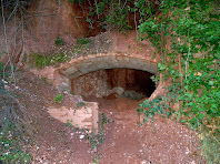 Mina d'aigua amb volta de canó feta de maó al marge de la pista a la Serra de Les Torretes