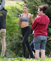 Adriana Lima posing in sports bra and holding weights