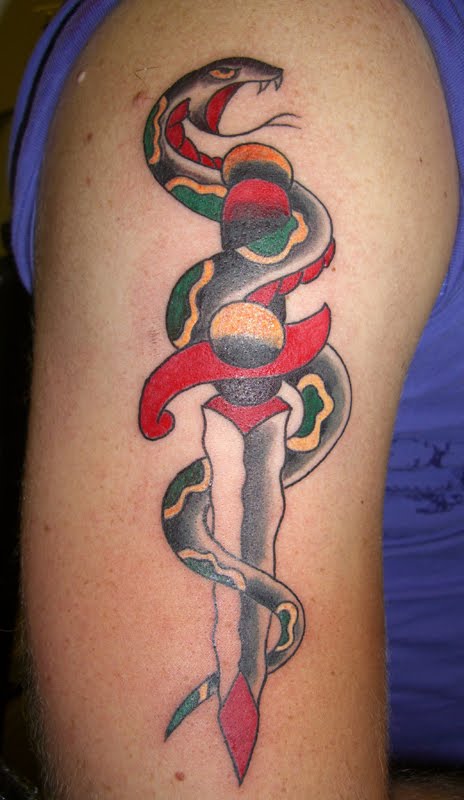 Coiled snake and dagger tattoo on arm.