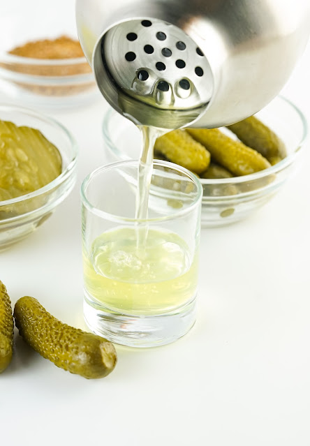 shot being poured into a glass from a shaker.