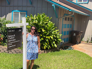 Robyn Curletti, Maui Luxury Real Estate Agent, in front of a "Sold" sign