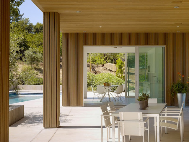 Terrace of Home with Wooden Pillars and White Open Dining Space near it