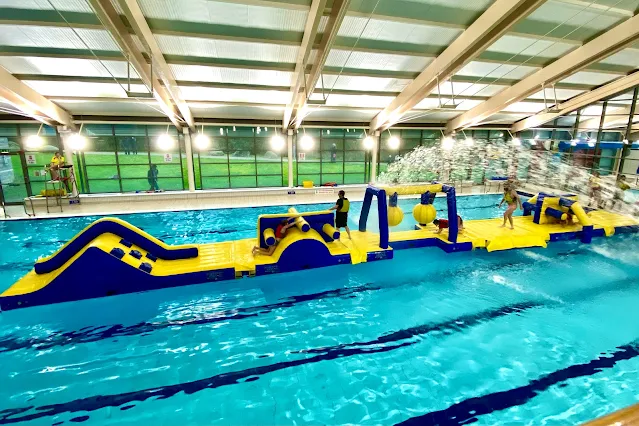 Inflatable course in blue and yellow in the middle of a swimming pool at Loughton leisure centre