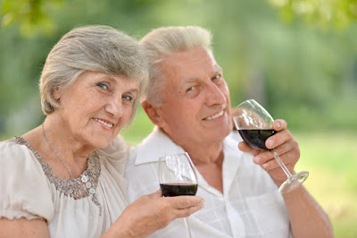 A happy elderly couple drinking wine. 