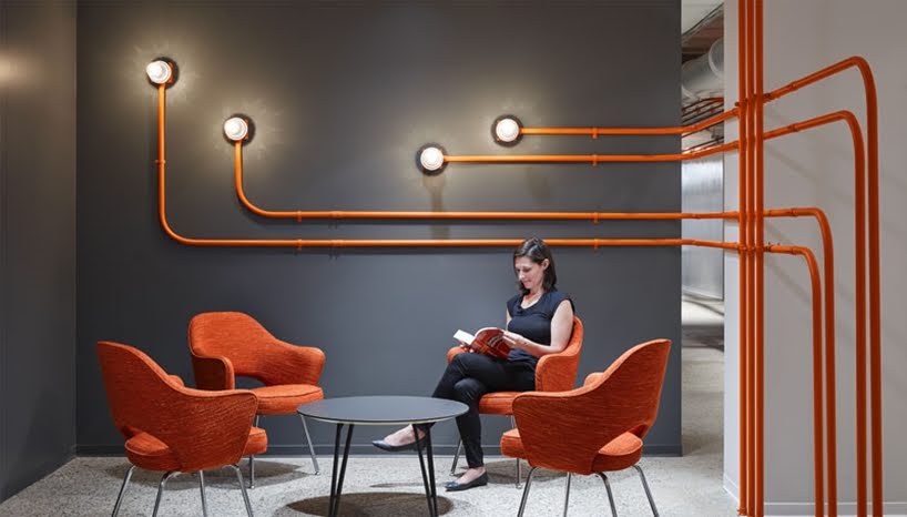 El diseño de esta oficina utiliza tubos de color naranja para guiar a las personas alrededor del espacio
