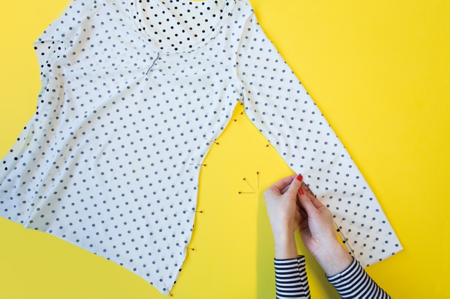 Overhead shot of hands pinning polka dot jersey top