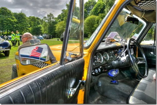 owner of classic new york taxi unaware of stars and stripes reflected in door mirror copy