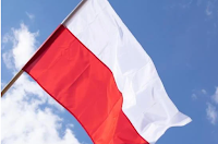 Biało czerwona flaga Polski powiewa na tle błękitnego nieba.