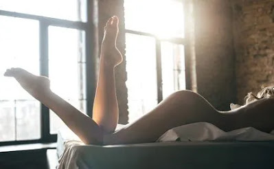 Jeune femme nue sur lit le bassin surélevé par deux oreillers attendant la fessée en bougeant les jambes (naked woman laying on the bed with 2 pillows under her belly waiting for spanking)