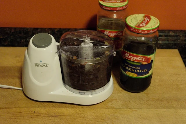 The kalamata olives being chopped up in the electric chopper for the Cheesy Olive Bread Recipe.