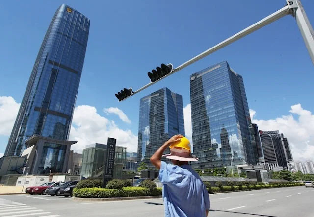  Image Attribute: epa01795959 A construction worker walks across a main street in the Futian district, the central business district of Shenzhen, China, 16 July 2009. EPA/YM YIK  .