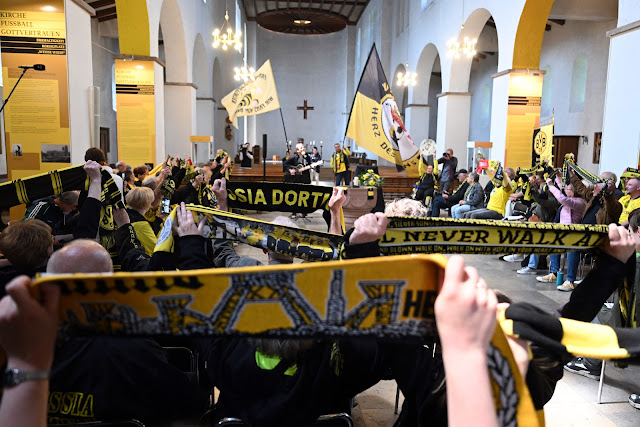Aficionados del Dortmund sostienen sus bufandas durante la misa en la iglesia fundacional del club, donde rezaron para que el equipo aurinegro gane el campeonato. Foto: Federico Gambarini/dpa Crédito: Federico Gambarini/dpa