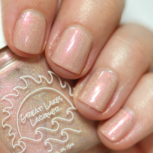 peachy holographic nail polish with red shimmer swatched on white person's nails