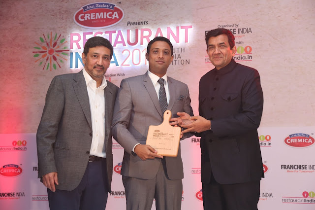 Mr. Ganeshan Maniyan receiving the award from Master Chef Sanjeev Kapoor