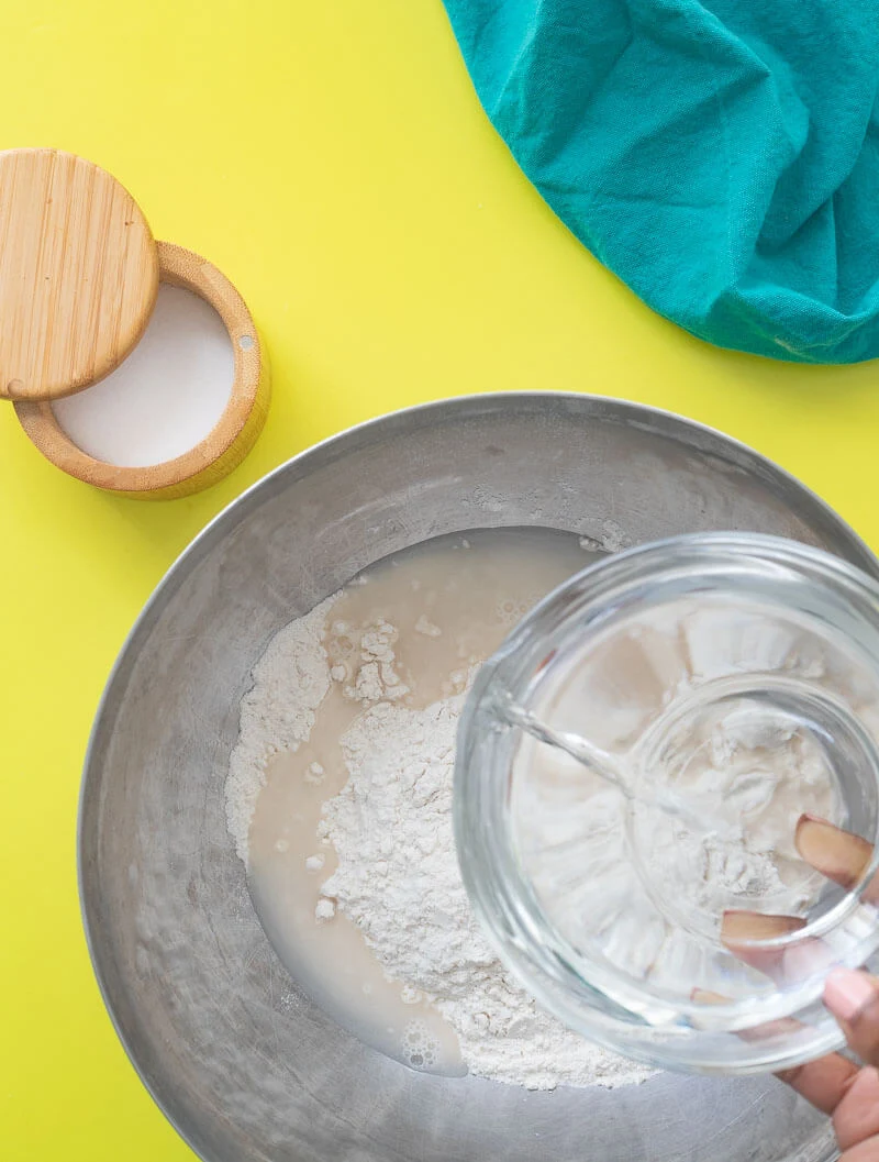 Adding water to the flour to make some boiled dumplings.