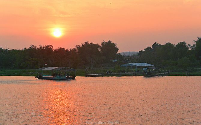 Kapal menyeberang kala senja di sungai Brantas