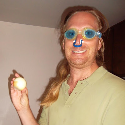 Jonathan Donihue holds onion while wearing goggles and nose plugs