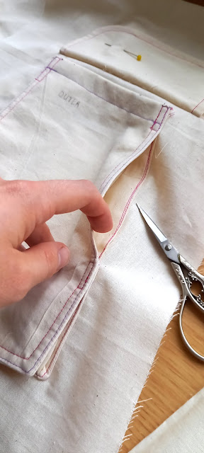 Image shows a hand holding the side entry of the pocket open to reveal the innermost lining top-stitched to the coat body.