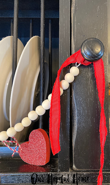 red velvet ribbon black sideboard cupboard wooden beads garland