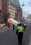 Runners continue to run towards the finish line as (boston )