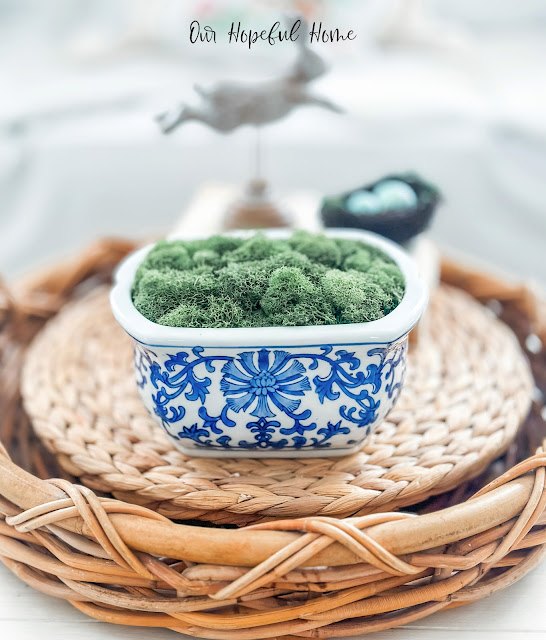 sea grass placemats in round basket with cachepot filled with preserved moss.