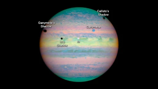 During a rare triple eclipse, three black spots, Io, Ganymede, and Callisto's shadow appears across the Jovian landscape.