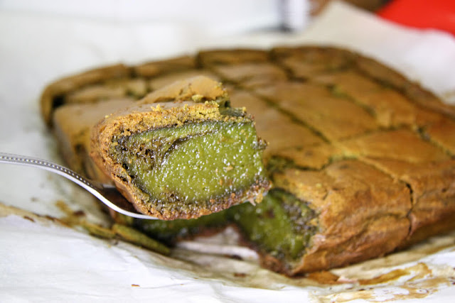 Mochi Matcha Cake cut into squares with one square being picked up by a fork.