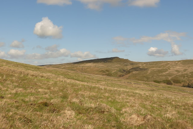 An escarpment on the horizon - blue sky above and a gently sloping hillside in the foreground.