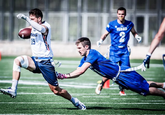Jogador de flag football da França corre com a bola e escapa do jogador de Israel durante os Jogos Mundiais de 2022