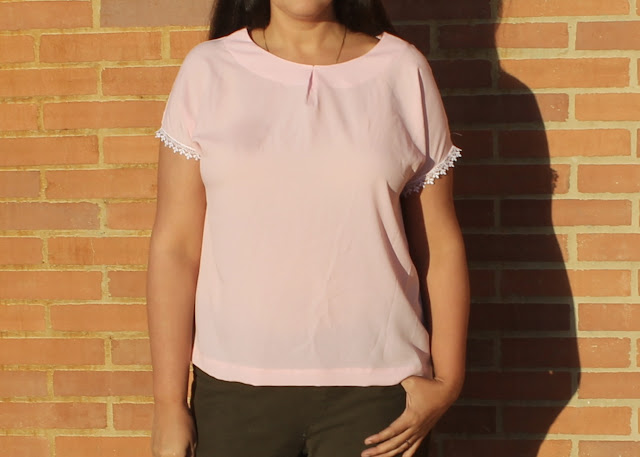 A woman wearing a pink crepe top with lace-trimmed sleeves made from the Avid Seamstress Drop-Sleeved Top sewing pattern.