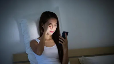 a girl using her phone on bed ,the girl is a phone addictive