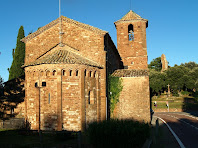 L'absis i el campanar de Sant Martí del Brull, i a la dreta les restes del Castell