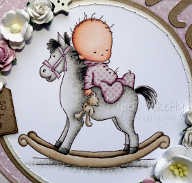 Circular pink baby girl card with baby on rocking horse (image from LOTV)