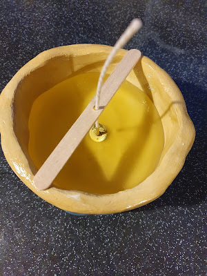 Hot wax poured into a homemade clay pot