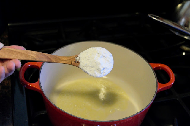 The pot, on the stove, with butter in it, with flour being added to it.