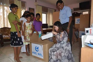 Miss. Feng Yao, Manager of Human Resource Dept, AVIC-INTL opens gifts of stationary for the girls at the orphanage