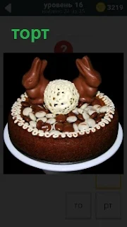 Приготовлен шоколадный торт с зайцами на верху, украшенный белым кремом по периметру 