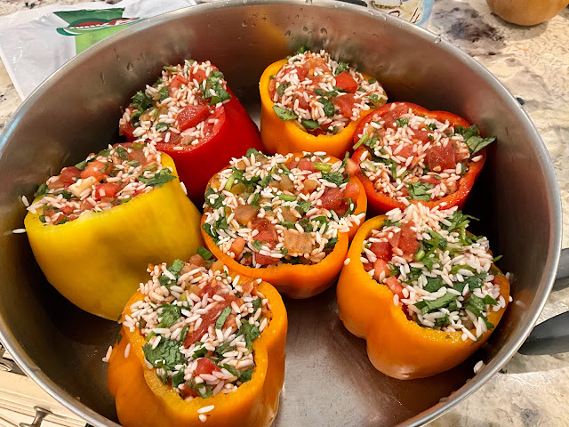 Cooking pot filled with bell peppers stuffed with rice, vegan