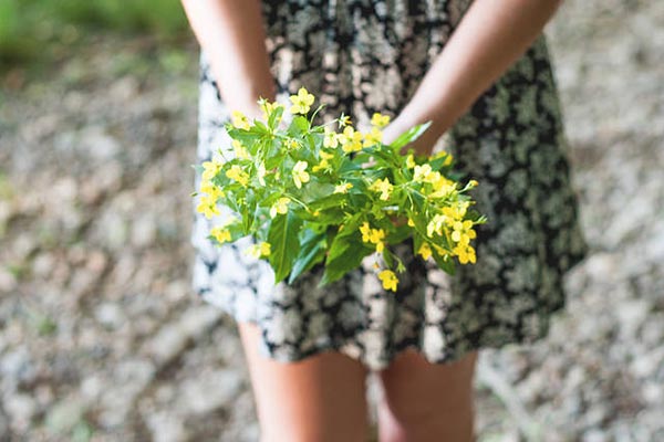 Muchacha con un ramos de flores en sus manos.