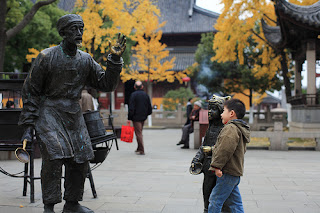 Guan Qian Street, a child is watching the statue in Guan Qian Street.